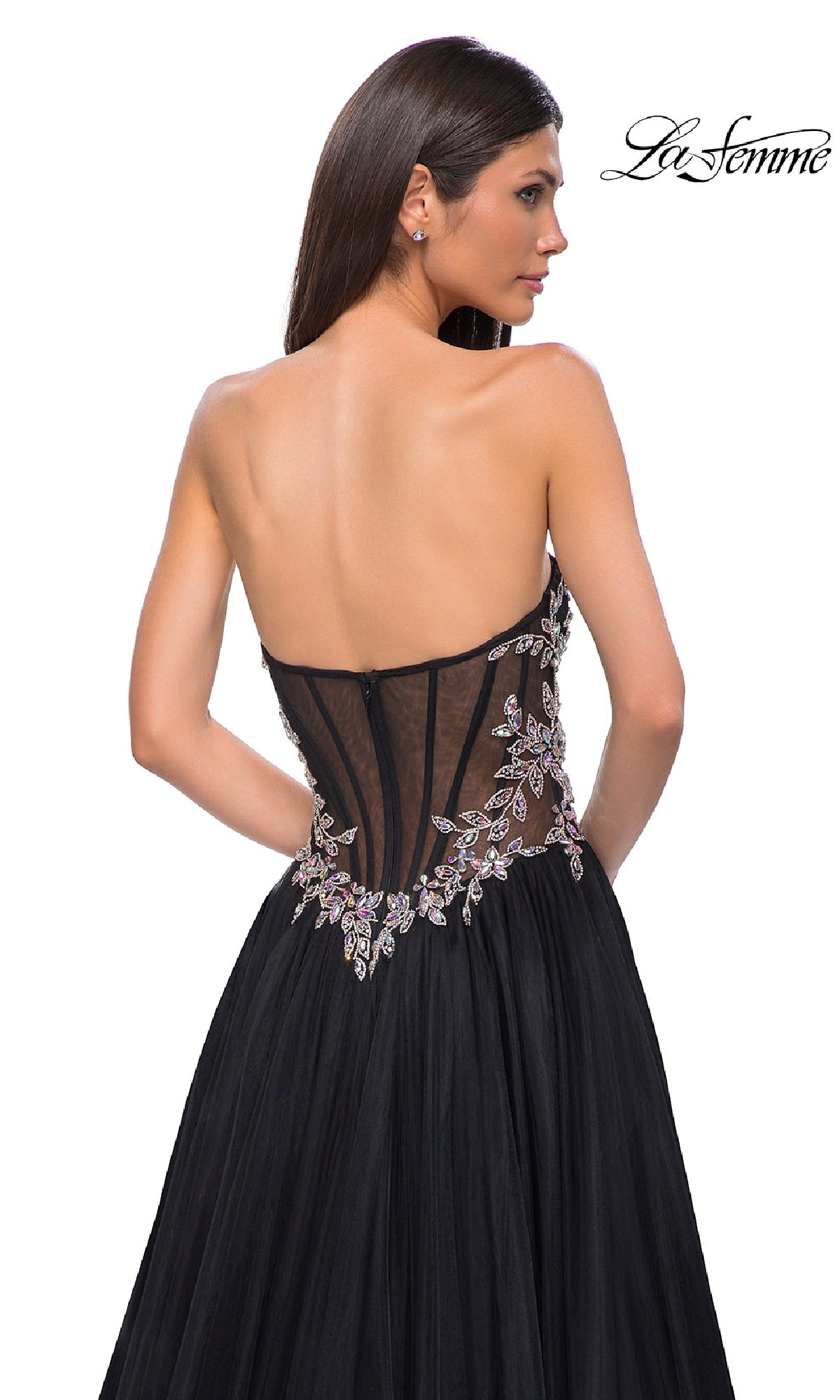 Woman wearing the La Femme 32862 Beaded-Corset Strapless Prom Gown with a sheer, beaded corset-style back and floral embroidery, standing against a white background.